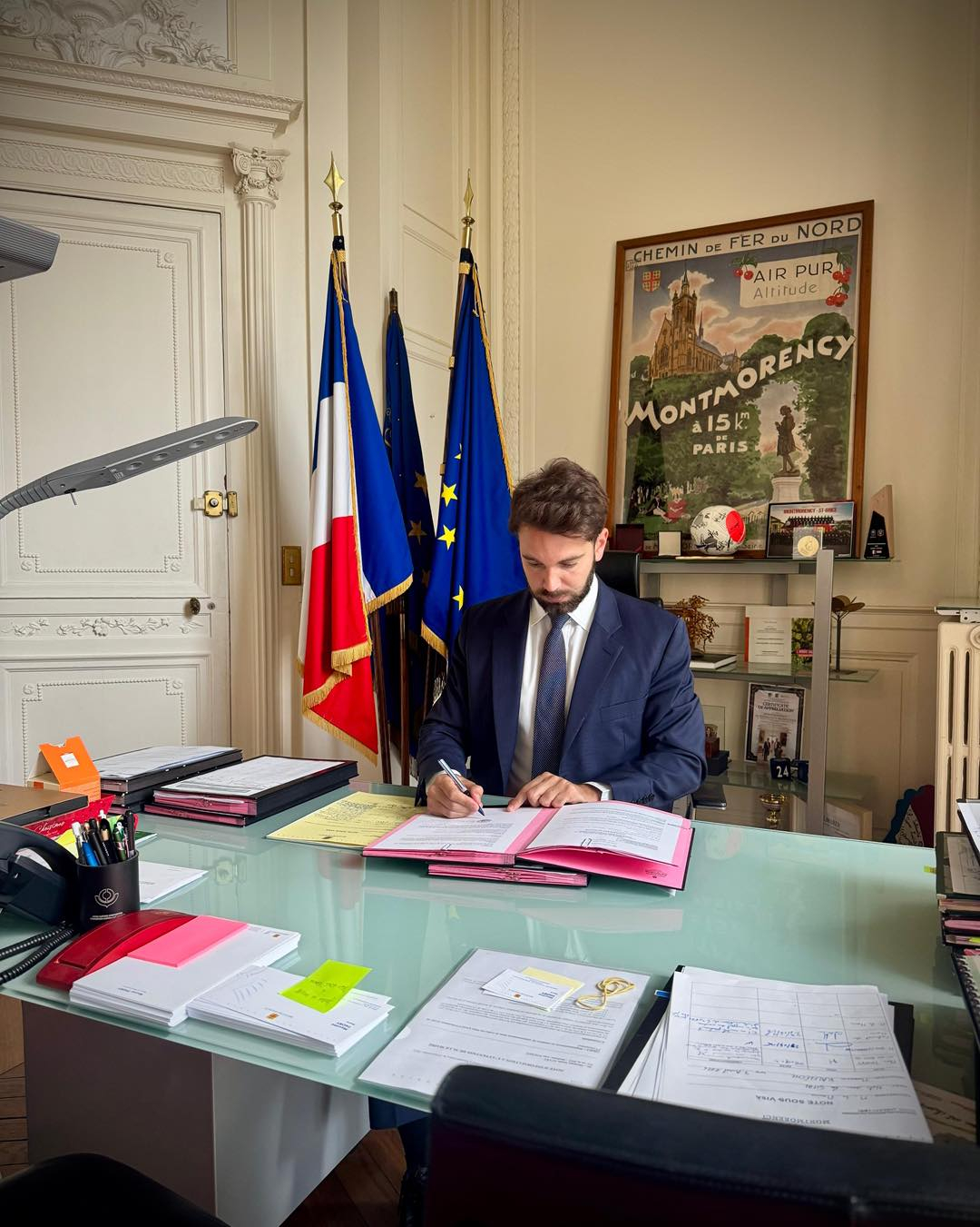 Le maire signe un arrêté dans son bureau