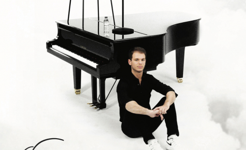 Portrait d'Alexandre Prévert devant un piano à queue