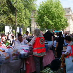 mobilier exposé lors de la brocante et visiteurs qui regardent le stand de la Croix-Rouge