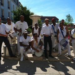 Monsieur le Maire Maxime Thory prend la pose avec la troupe de batucada sur la place du marché