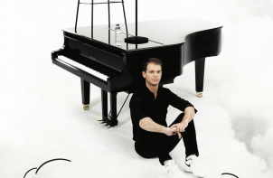 Portrait d'Alexandre Prévert devant un piano à queue