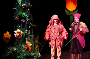 Comédiens déguisés sur scène avec un décor végétal